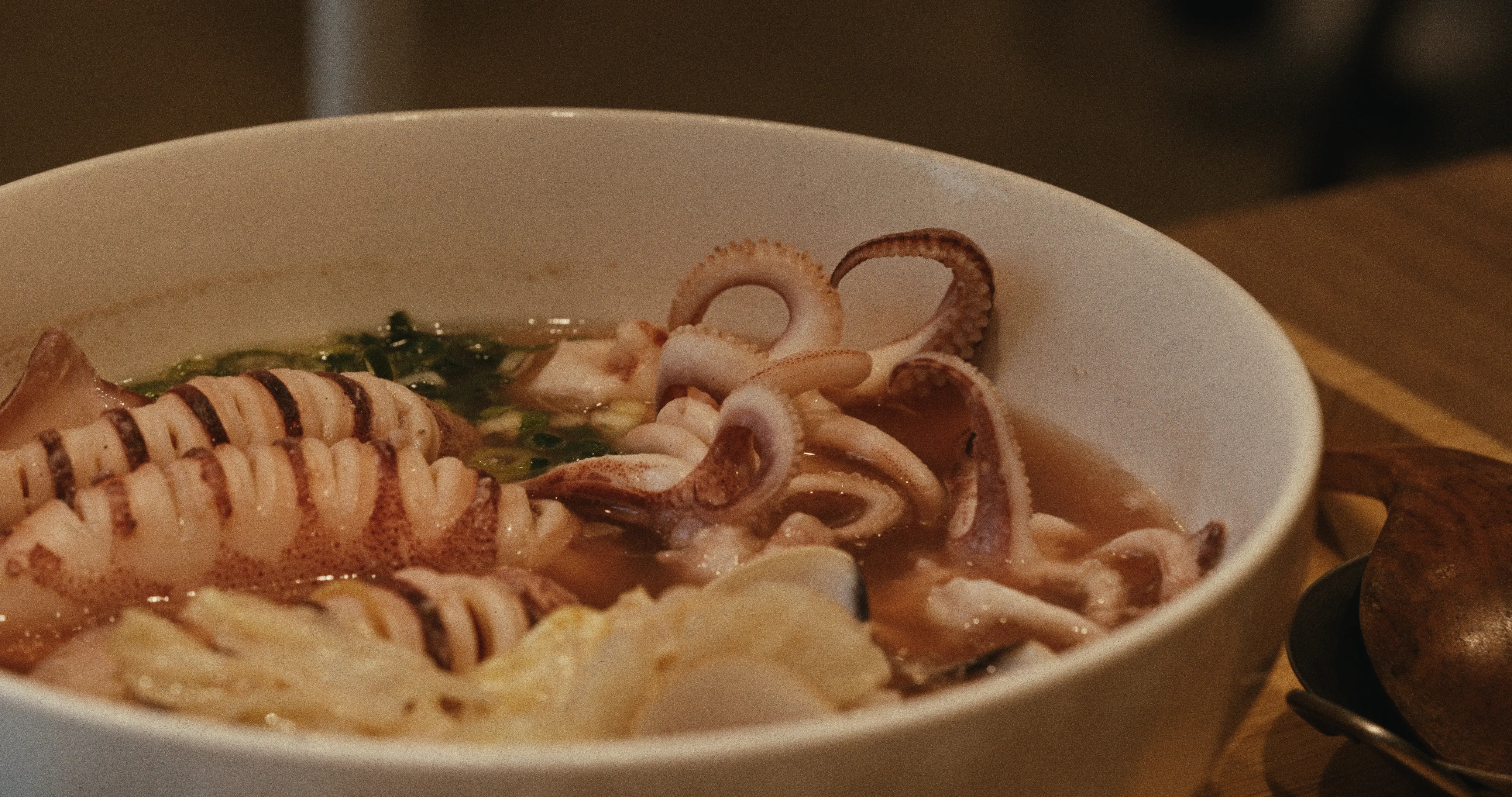 蔥蔥Cong Cong Diner招牌野生小卷海味米粉特寫，白瓷碗裡盛著捲曲小卷、蛤蜊與蔥花湯底